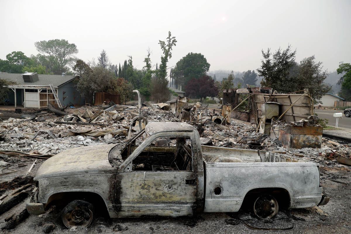 A burned out vehicle sits in front of a wildfire-ravaged home Saturday, July 28, 2018, in Redding, Calif. (AP Photo/Marcio Jose Sanchez)