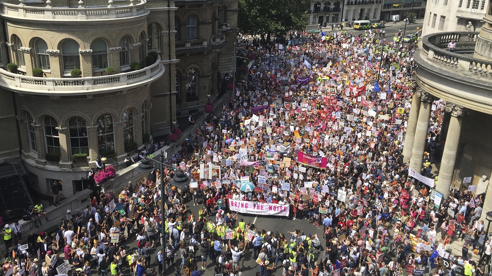Protesters for the 'Stop Trump' Women's March gather in London on Friday [AP]