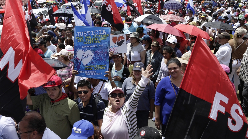 Ortega supporters waved red-and-black Sandinista Front flags [Arnulfo Franco/AP]