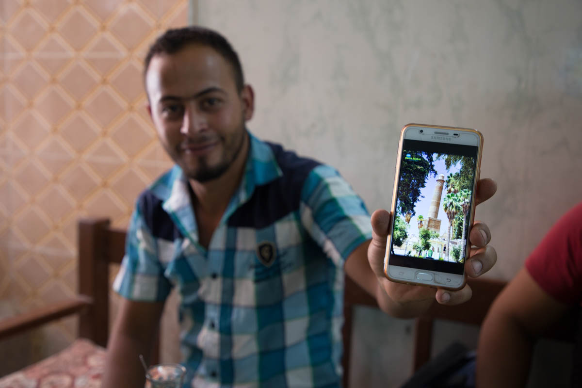 Picture 6 A resident of Mosul shows an old picture of the minaret of al-Nuri mosque. The leaning minaret was famous for its unique inclination. It was destroyed at the same time as the Great Mosque o