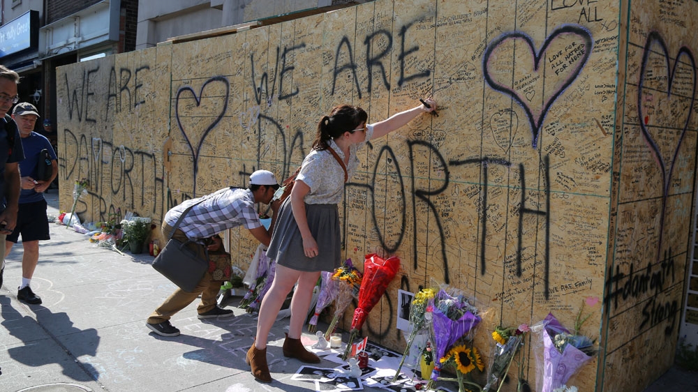 People write messages on construction boarding after a shooting on Danforth Avenue in Toronto [Chris Helgren/Reuters]