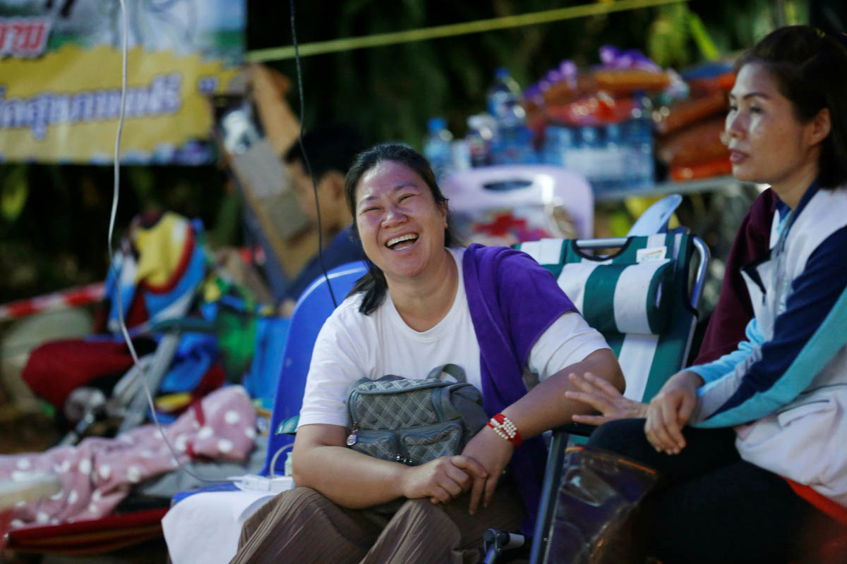 A family member smiles near the Tham Luang cave complex, as members of an under-16 soccer team and their coach have been found alive according to local media, in the northern province of Chiang Rai, T