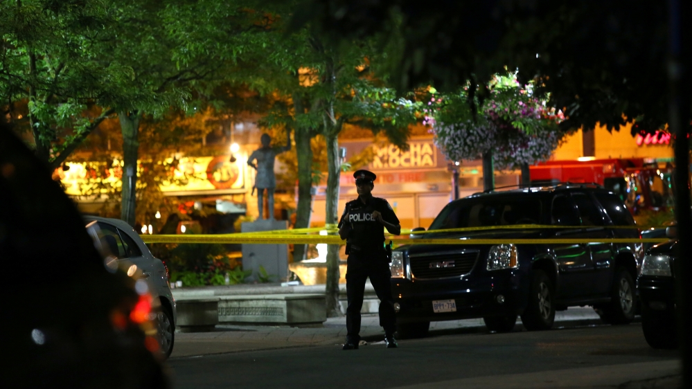 A police officer stands guard at the scene of a mass shooting in Toronto