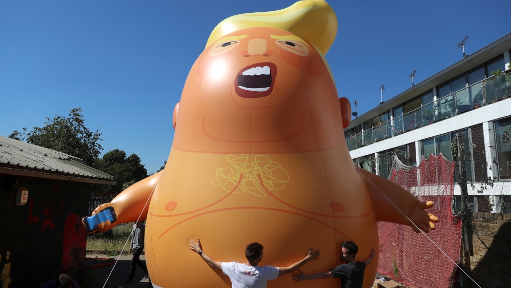 People inflate a helium filled Donald Trump blimp which they hope to deploy during The President of the United States'' upcoming visit, in London