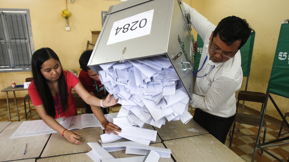 Polling station officials empty ballots boxes before counting at a polling station in Phnom Penh, Cambodia, Sunday, July 29, 2018. With the main opposition silenced, Cambodians were voting in an elect
