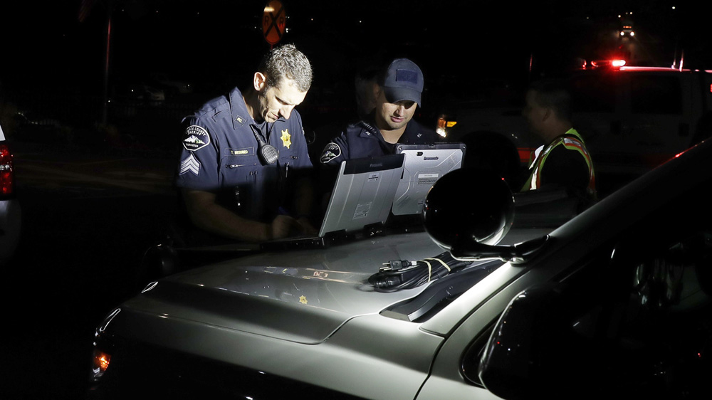 Law enforcement officials work at a staging area investigating the plane crash [Ted S Warren/AP]