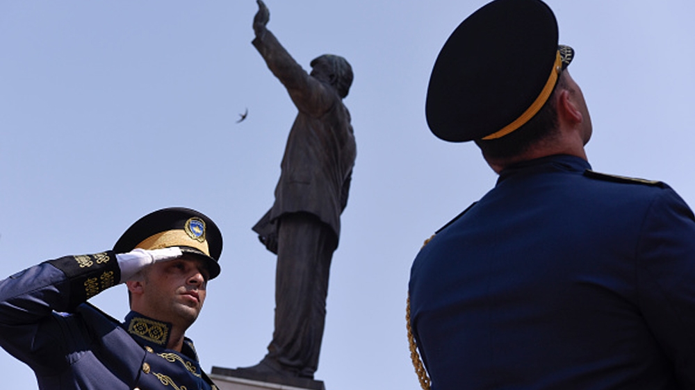 Members of the Kosovo Security Force (KSF) stand guard next to a statue of former US President Bill Clinton during a ceremony marking the 4th of July in Pristina [Armend Nimani/AFP/Getty Images]