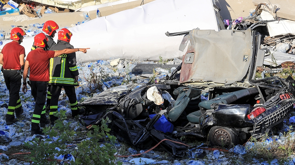 Italian rescuers search the scene of the collapsed Morandi motorway bridge to look for victims and survivors in the northern port city of Genoa [Valery Hache/AFP]