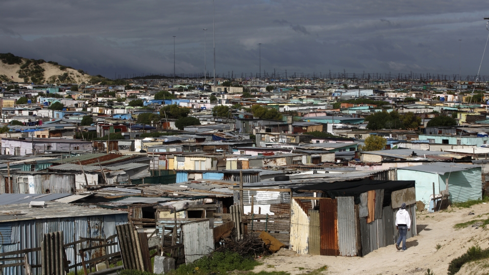 Residents walk through shacks in Cape Town''s crime-ridden Khayelitsha township in this picture taken July 9, 2012.