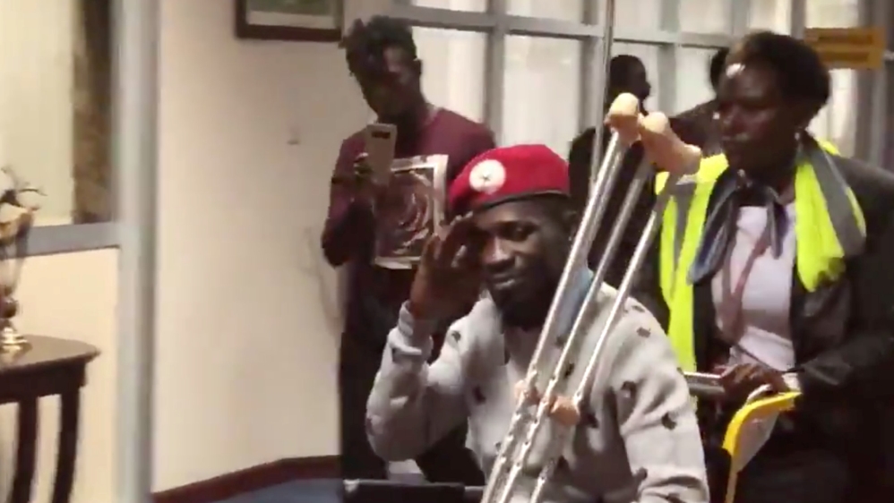 Bobi Wine is seen in a wheelchair just before his departure at Entebbe International Airport, in Entebbe