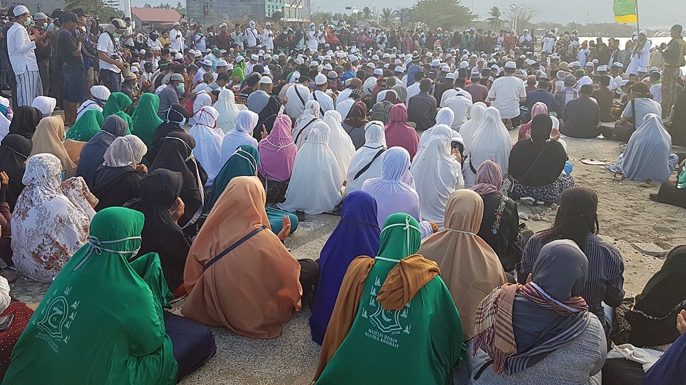Women attend a mass prayer for Palu at Talise beach for the one-week tsunami anniversary in Palu, Indonesia [Ted Regencia/Al Jazeera] 