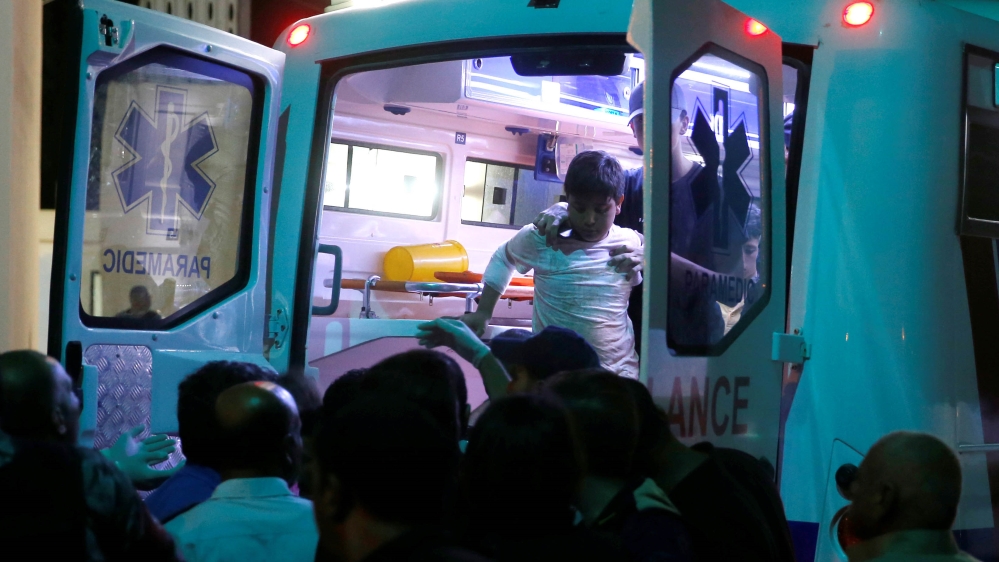 A child survivor is helped as residents and relatives gather outside a hospital near the Dead Sea, Jordan October 25, 2018. REUTERS/Muhammad Hamed