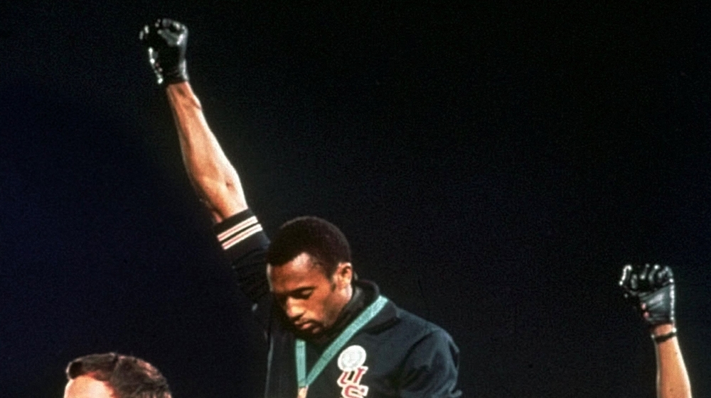 Australian silver medalist Peter Norman, left, stands on the podium as Americans Tommie Smith, centrr, and John Carlos raise their gloved fists in a human rights protest in 1968 [File: AP Photo]