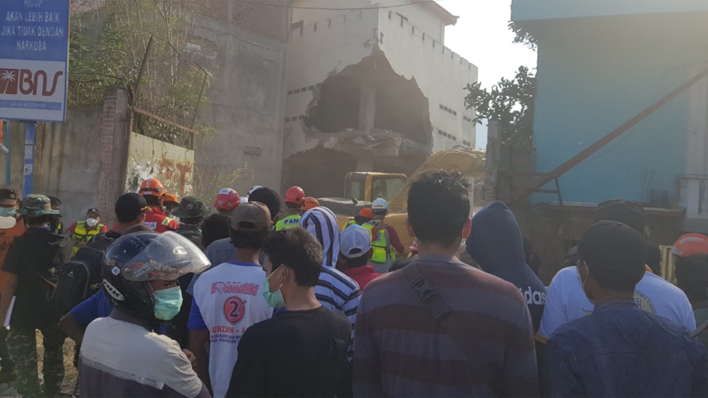 Volunteers carry out search and rescue operation at a Palu wedding hall where six people are believed to be trapped [Ted Regencia/Al Jazeera]