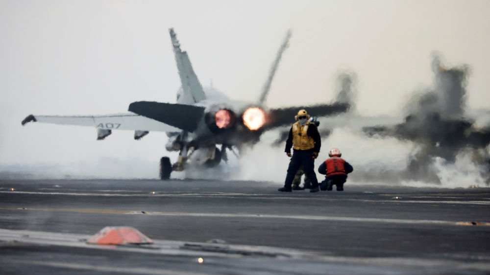 A US Navy F-18 fighter jet takes off from the deck of an aircraft carrier [Reuters]