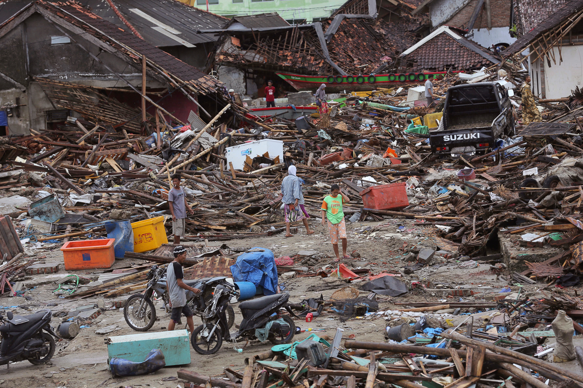 People inspect the damage at a tsunami-ravaged village in Sumur, Indonesia, Tuesday, Dec. 25, 2018. The Christmas holiday was somber with prayers for tsunami victims in the Indonesian region hit by wa