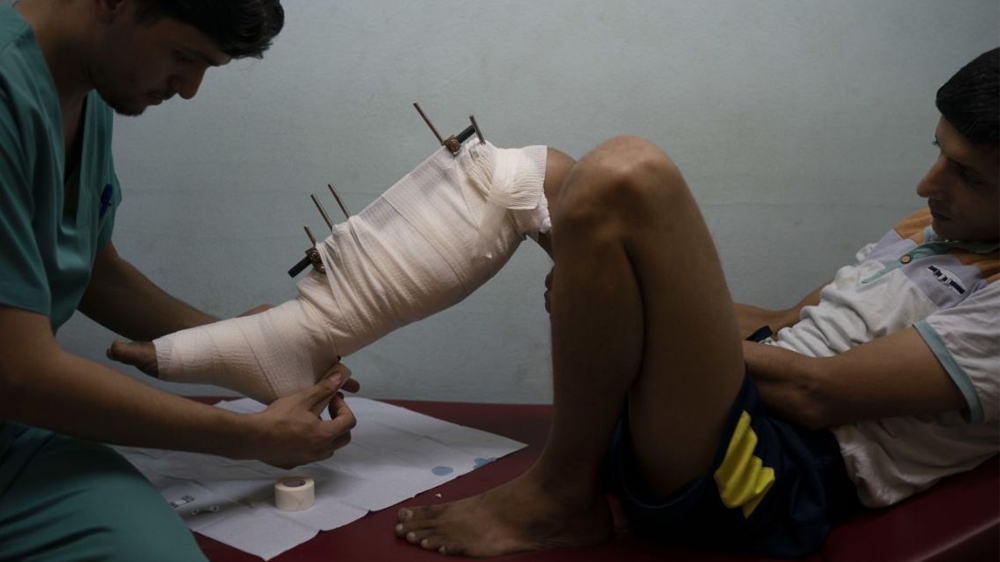 Mahmoud Abu Assi, who was shot in the leg during a demonstration, has his bandage changed in a clinic run by MSF in Gaza City [Associated Press]
