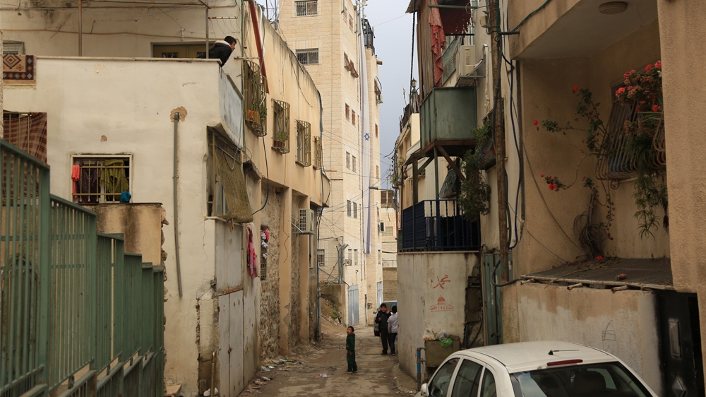 An Israeli flag covers six floors of a building occupied by settlers in Batan al-Hawa [Mersiha Gadzo/Al Jazeera]