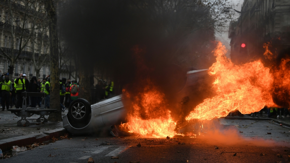 A car burns during a 'yellow vest' protest against rising living costs on the Champs Elysees on December 1 [Alain Jocard/ AFP]
