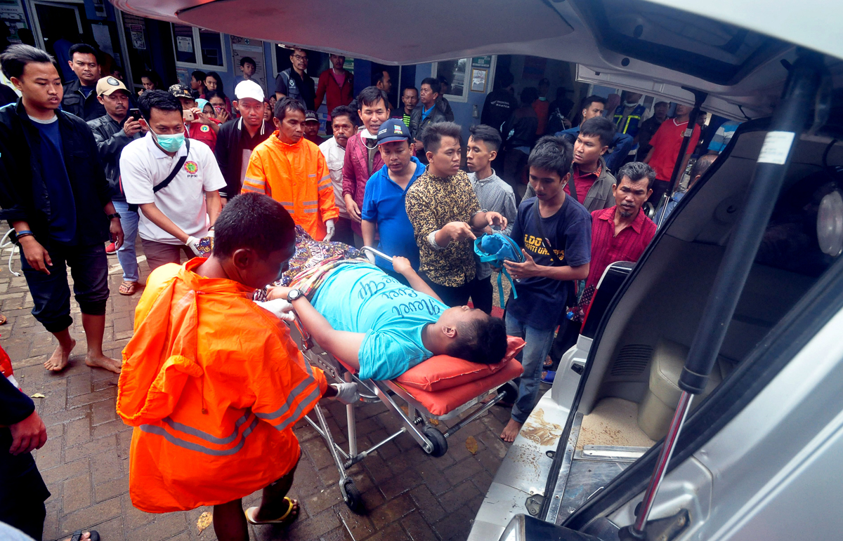 Indonesian officers carry an injured person into an ambulance after a tsunami hit the Sunda Strait in Banten, Indonesia 23 December 2018. According to the Indonesian National Board for Disaster Manage