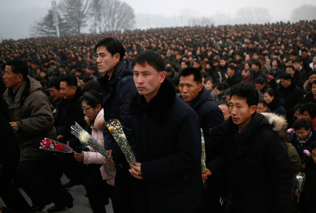 North Koreans hold flowers to be laid at the bronze statues of their late leaders Kim Il Sung and Kim Jong Il at Mansu Hill Grand Monument in Pyongyang, North Korea, Monday, Dec. 17, 2018. Tens of tho
