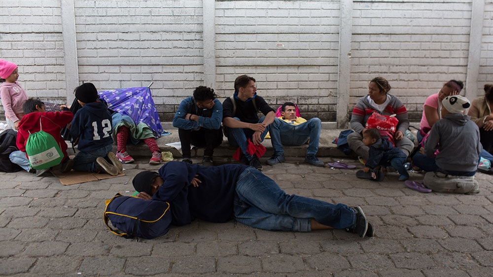 Honduran migrants and refugees rest outside the Esquipulas Casa de Migrante [Jeff Abbott/Al Jazeera]