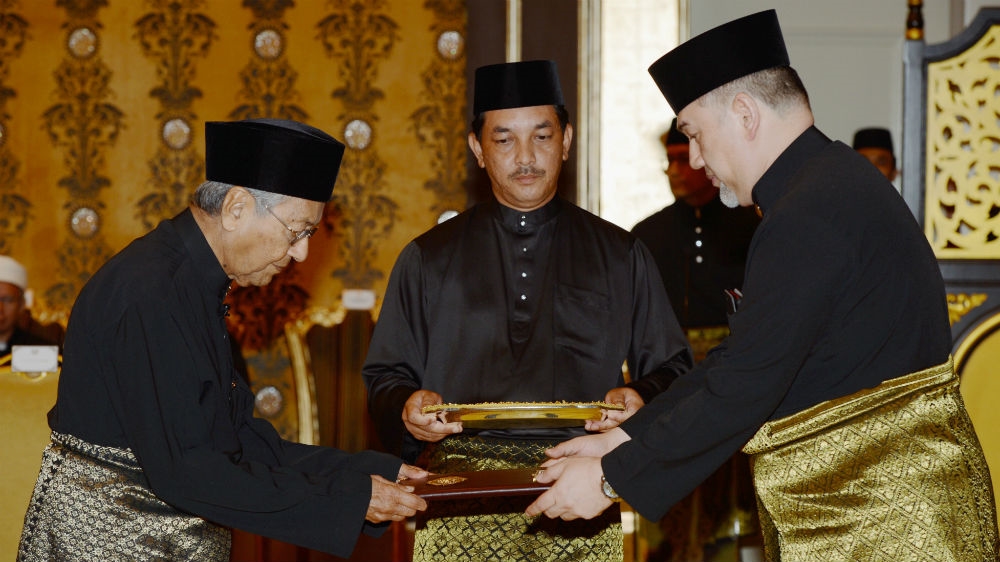 Mahathir Mohamad, left, is sworn in as Malaysia's prime minister by Sultan Muhammad V, right, in May 2018 [Rosli Awang/Bernama via AP Photo] 