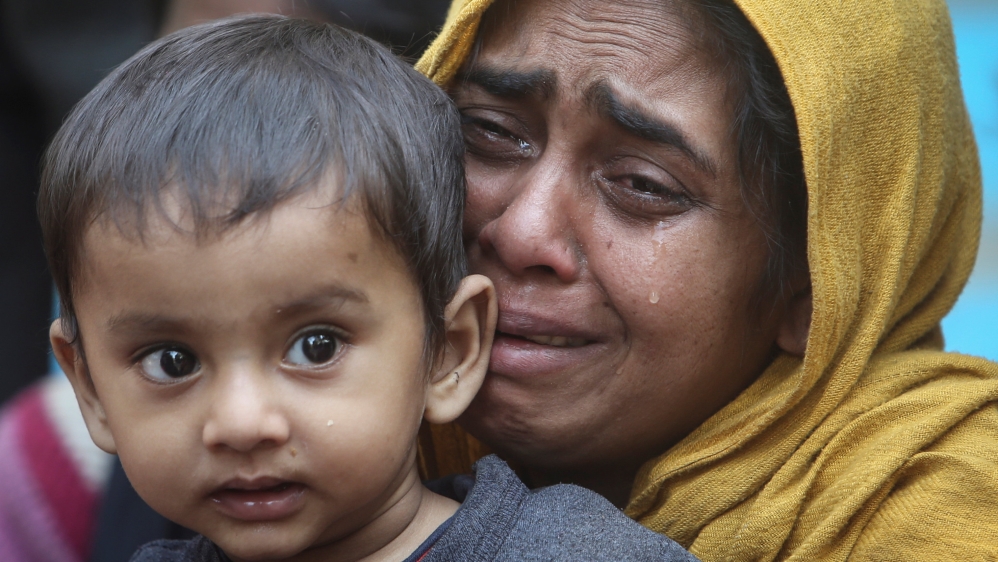 A Rohingya Muslim woman cries as she holds her daughter
