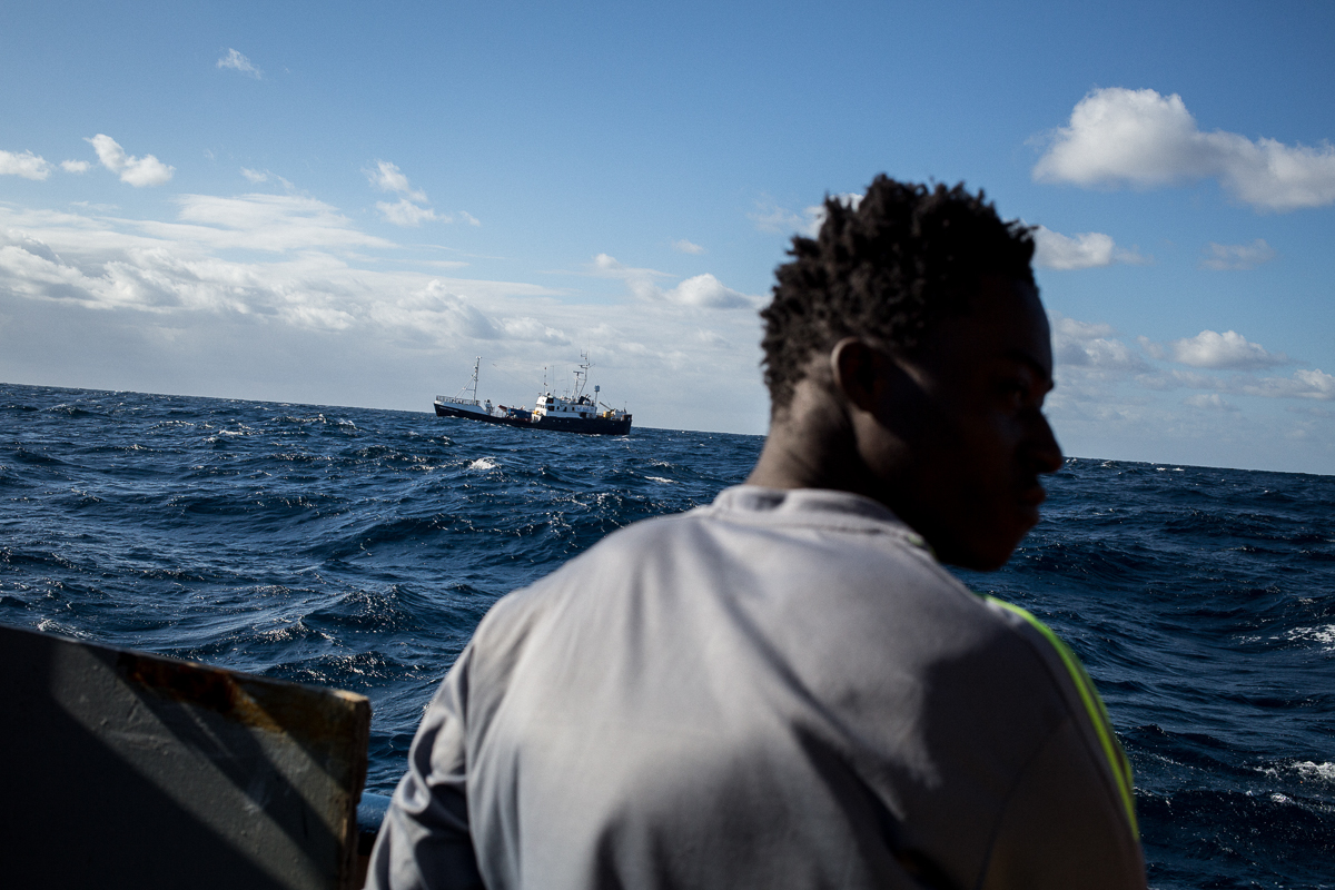 One of the migrants looking at the ''Professor Alberech Penck'' a second rescue boat carring other migrants sailing south of Malta. Life onboard the Dutch-flagged rescue vessel Sea Watch 3 is hard and f