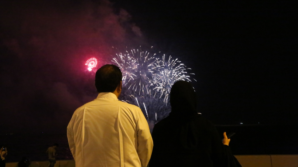 A couple enjoys the fireworks on Doha's Corniche [Showkat Shafi/Al Jazeera]