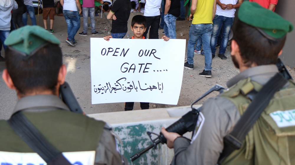 Palestinians from the West Bank village of Al-Zaayyim call for the opening of the aparheid wall gate that leads from Jerusalem to the village on May 8, 2015. The gate had been held closed by Israeli authorities for over two weeks [Ahmad Al-Bazz/Activestills/Al Jazeera]