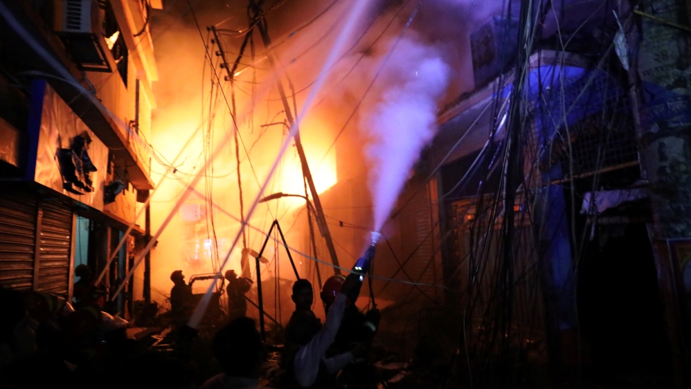 Firefighters work at the scene of the blaze [Mohammad Ponir Hossain/Reuters]