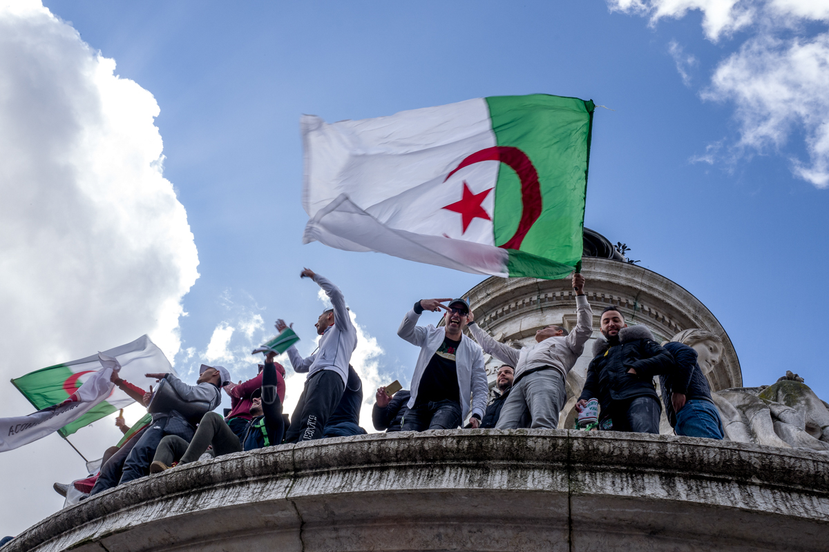 A group of Algerian protesters stand on top of the Monument ‡ la RE`publique during a demonstration against Algerian President Abdelaziz Bouteflika in Place de la RE`publique in Paris, France. Photo b