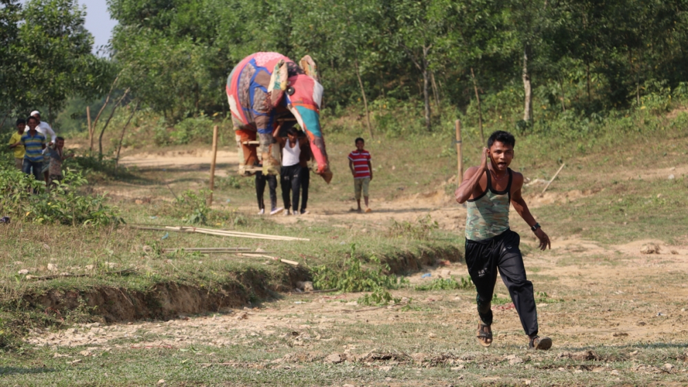 The elephant tusk force demonstrates to their community how not to react if an elephant comes into the camp [Susannah Savage/Al Jazeera]