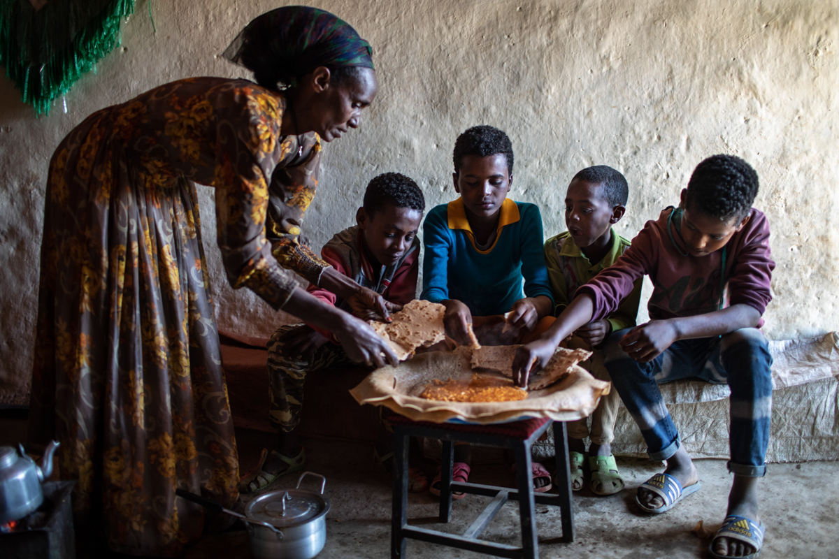 Febedu Mehari serves a meal of injera and a yellow split pea dish to her children in Hadush Emba, Debubawi Zone, Tigray Region, Ethiopia, on February 7, 2019. “My oldest daughter wants to migrate to S