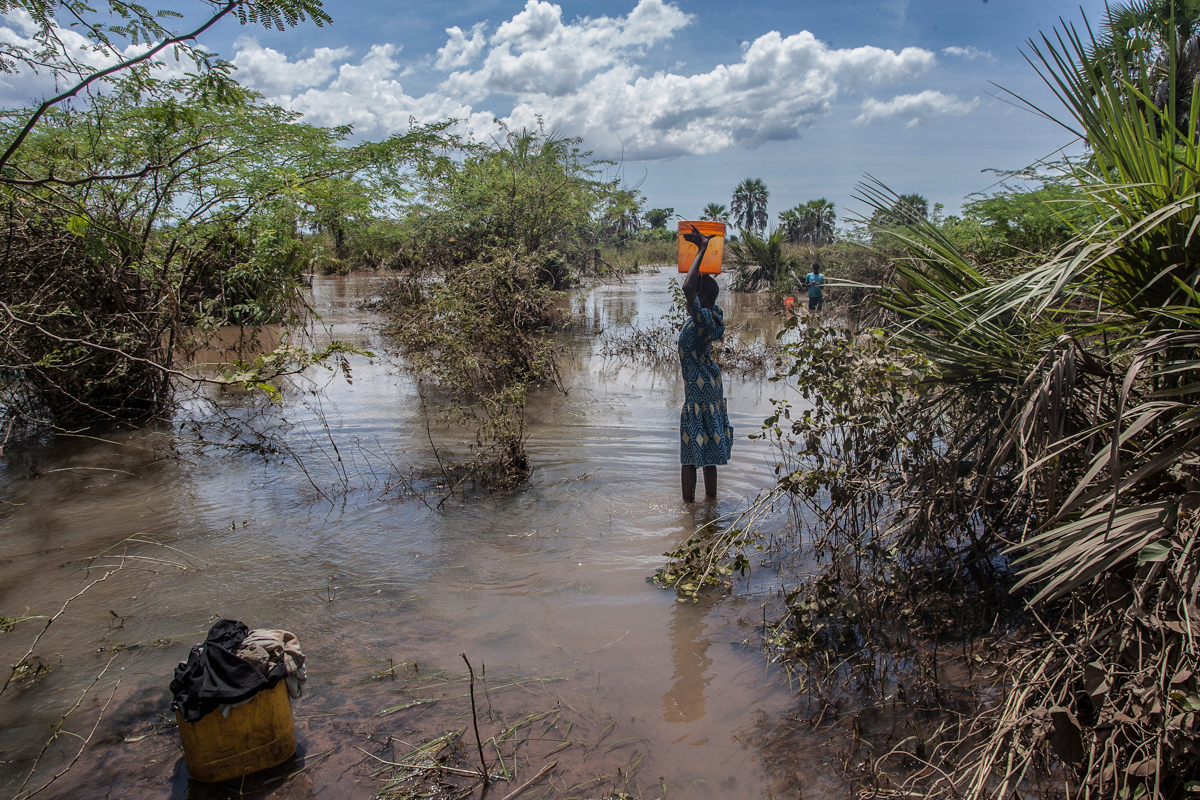 A girl fetches water from a river created by flood water near Nsusa Village Island camp for displaced people due to the floods in the Nsanje district of southern Malawi, on March 15, 2019. - At least