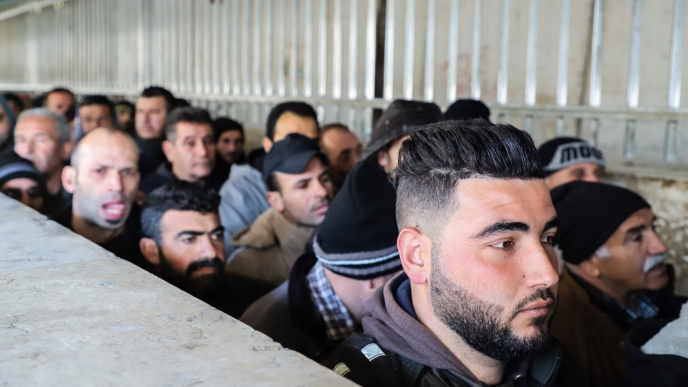 Palestinian men queue at the Checkpoint 300 near Bethlehem