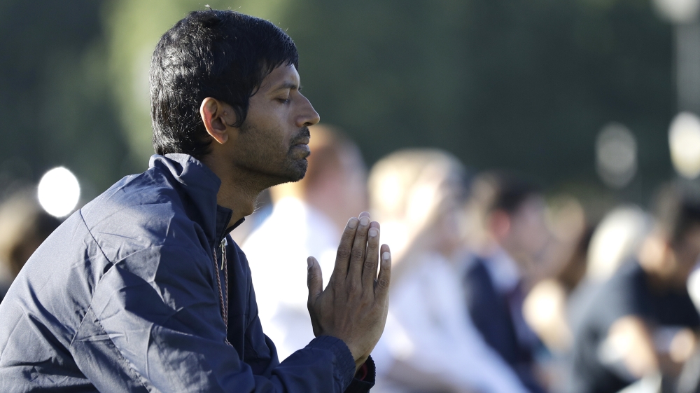 A man prays during a vigil in Hagley Park following the March 15 mass shooting in Christchurch, New Zealand, Sunday, March 24, 2019