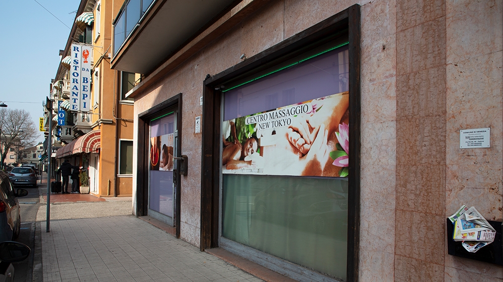 Several women work from inside massage parlours [Elisa Oddone/Al Jazeera]