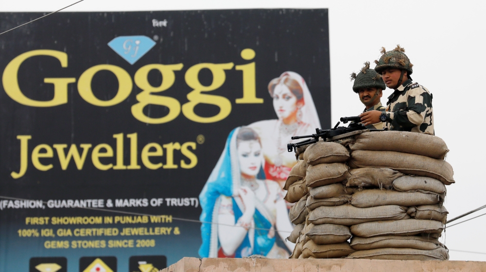 Border Security Force soldiers keep guard before the arrival of Indian Air Force pilot on the outskirts of the northern city of Amritsar, India [Danish Siddiqui/Reuters]