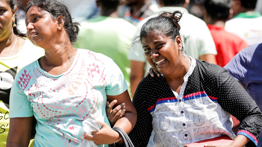 Relatives of victims react at a police mortuary after Sunday's bomb blasts [Dinuka Liyanawatte/Reuters]