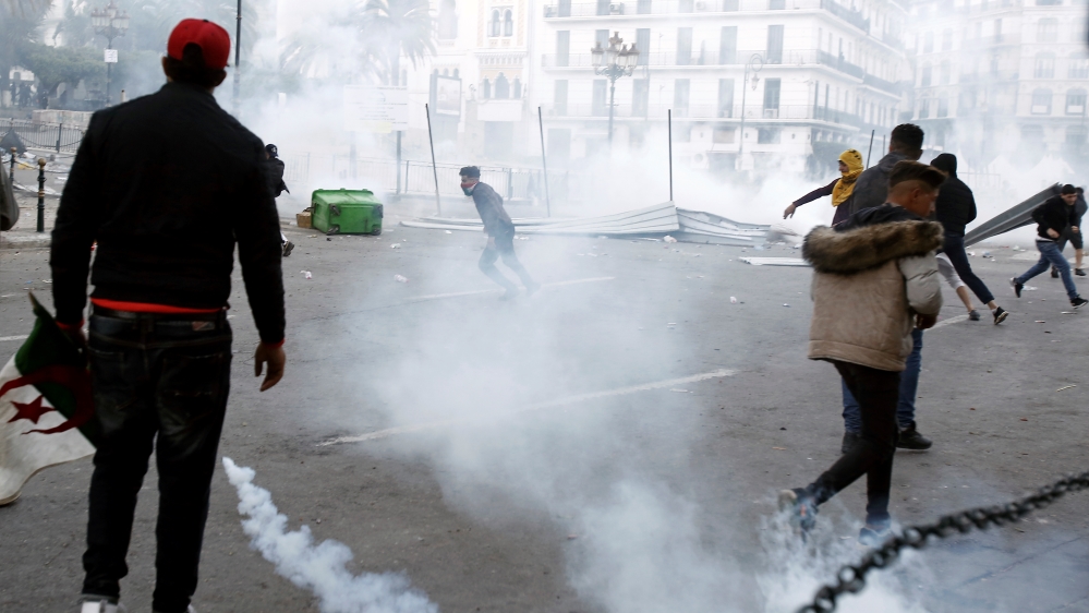 Anti-riot police fire tear gas as they confront some youths after a protest in Algiers