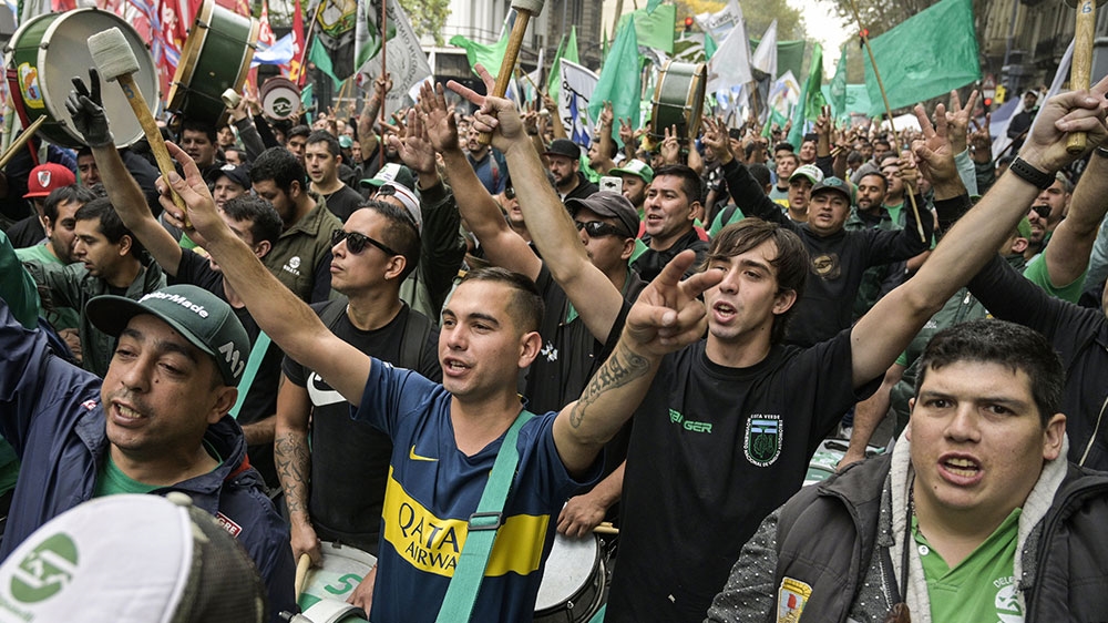 Members of the Mechanic and Automotive Transport Union (SMATA) sing the national anthem in a protest near Plaza de Mayo square during a partial strike against the economic policies of the government in Buenos Aires [Juan Mabromata/AFP] 