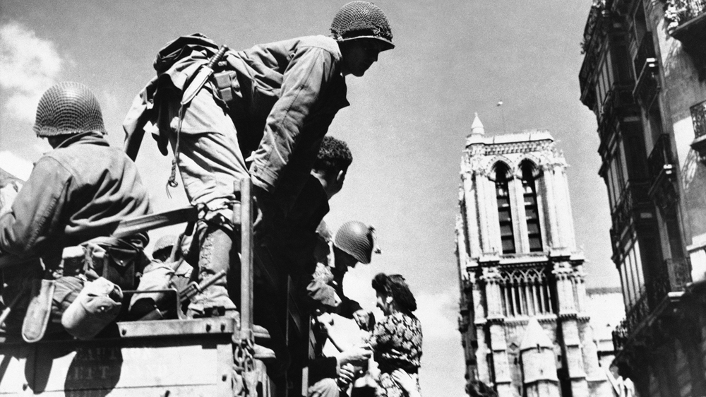 American soldiers are greeted by French women in the shadow of Notre Dame Cathedral in Paris in August 1944 [AP Photo]
