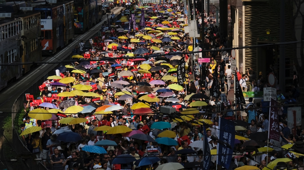 Demonstrators hold yellow umbrellas, the symbol of the Occupy Central movement, during the protest to demand authorities scrap a proposed extradition bill with China [Tyrone Siu/Reuters]