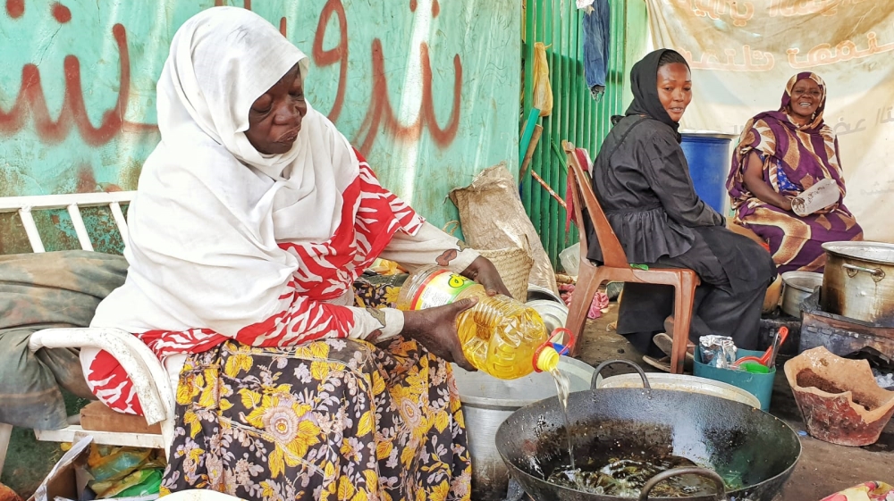 Female activists such as Awadia Mahmoud Koko, left, have been serving meals to protesters at the Khartoum sit-in [Hamza Mohamed/Al Jazeera]
