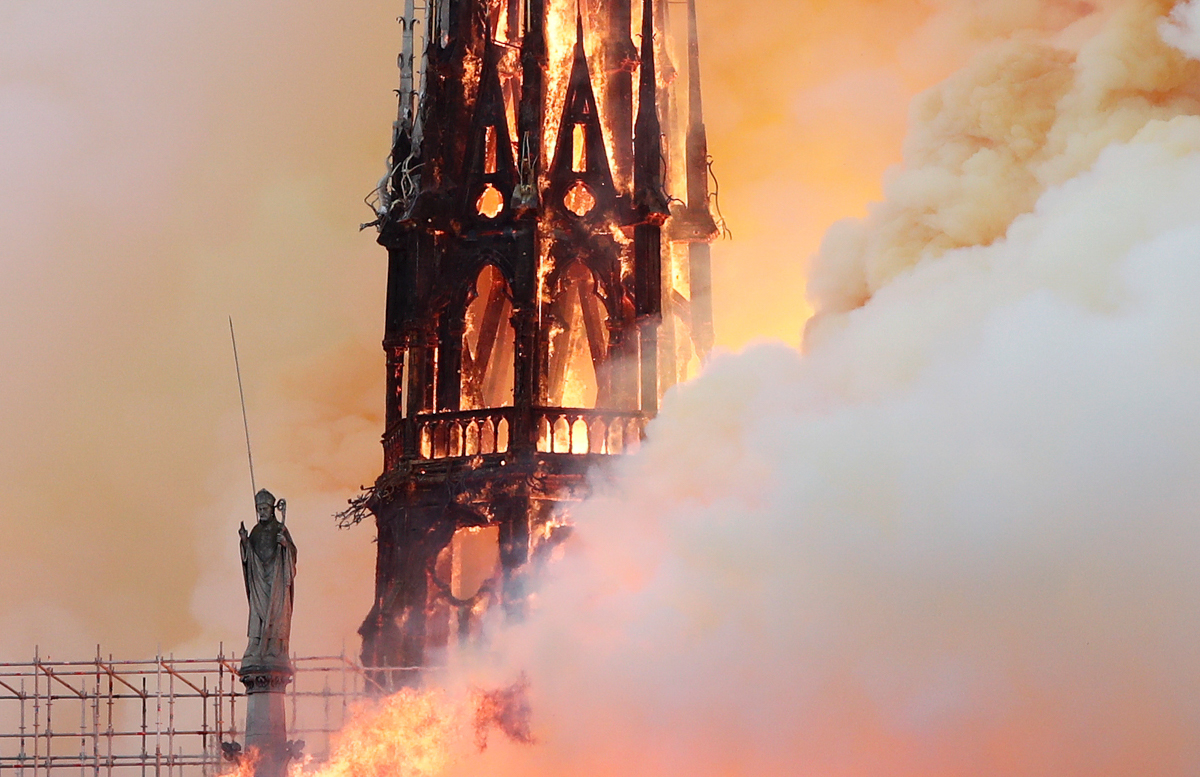 Smoke billows as fire engulfs the spire of Notre Dame Cathedral in Paris, France April 15, 2019. REUTERS/Benoit Tessier -