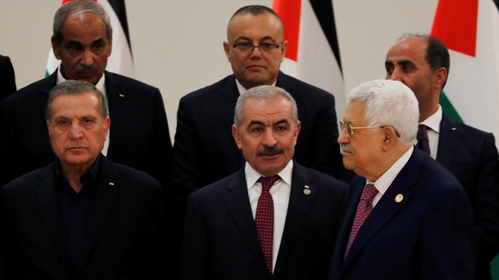 Palestinian President Mahmoud Abbas stands next to new Prime Minister Mohammad Shtayyeh and other members of the new government during a swearing in ceremony, in Ramallah in the Israeli-occupied West