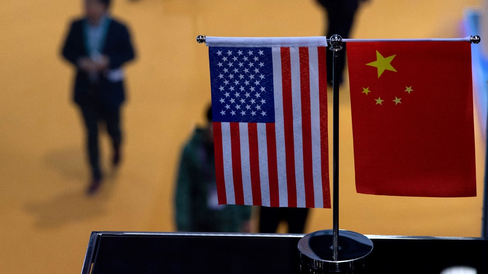 Chinese and US flags fly at a booth during the first China International Import Expo in Shanghai