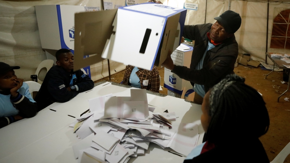 Election official empties a ballot box as counting begins after polls closed in Alexandra township in Johannesburg